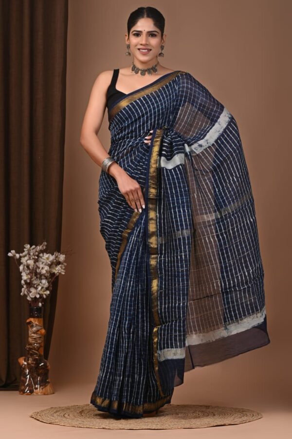 Woman draped in navy blue hand block printed Maheshwari silk saree with gold zari border