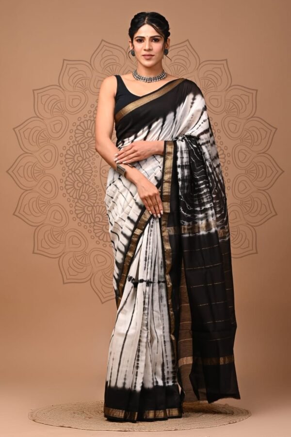 Woman draped in black and white Shibori tie-dye Maheshwari silk saree with gold zari border