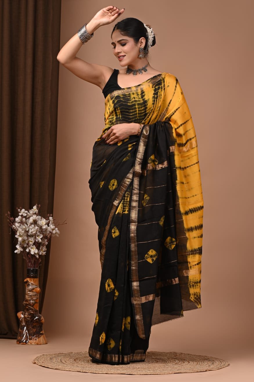 Woman wearing black and yellow Shibori hand block printed Maheshwari silk saree with zari border