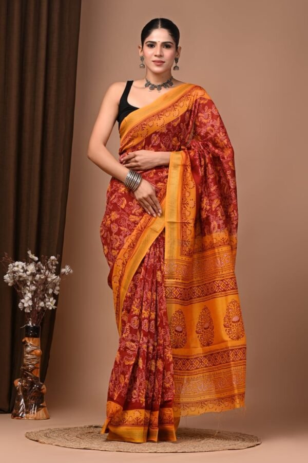 Woman wearing maroon and mustard floral hand block printed Maheshwari silk saree with paisley pallu