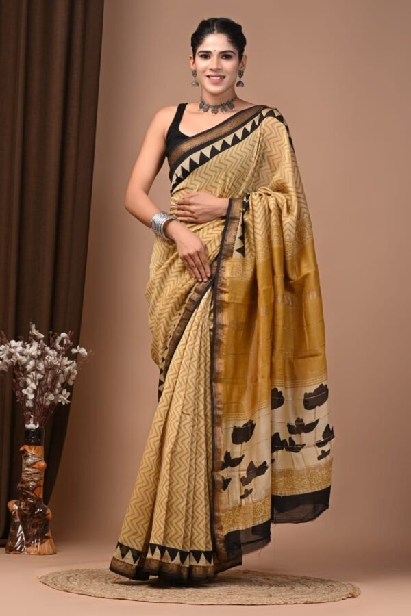 Woman wearing mustard and black zigzag hand block printed Maheshwari silk saree with floral pallu