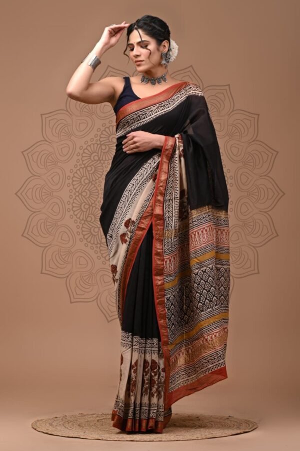 Woman wearing black hand block printed Maheshwari silk saree with floral border and geometric pallu