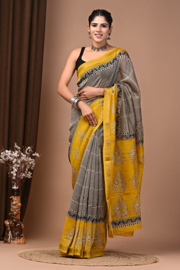Woman wearing beige and black striped hand block printed Maheshwari silk saree with mustard floral pallu