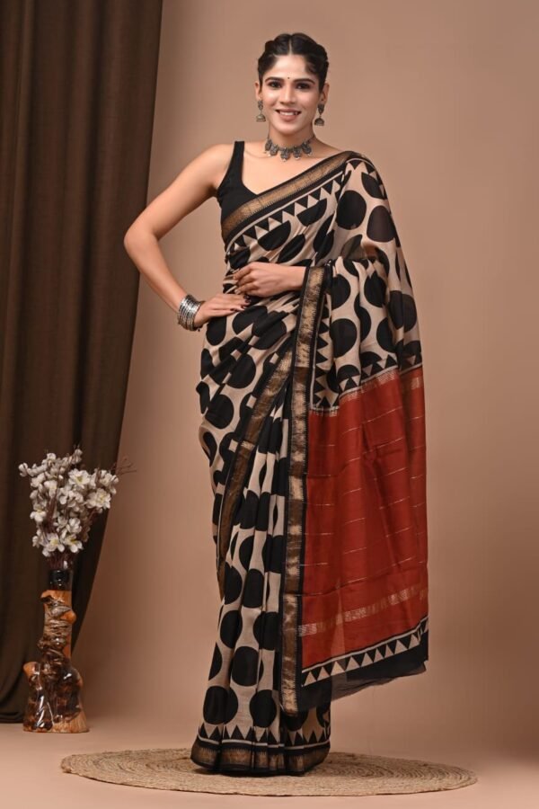 Woman wearing beige and black circle print Maheshwari silk saree with rust-red zari pallu