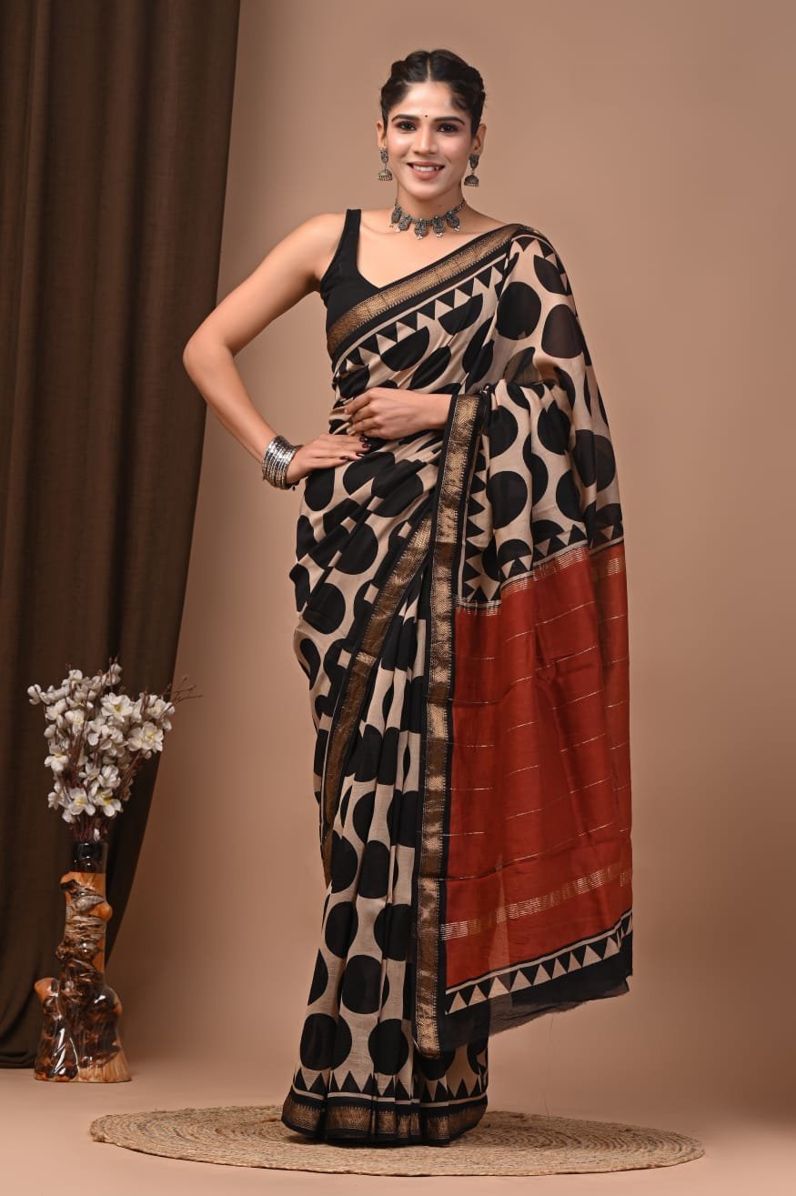Woman wearing beige and black circle print Maheshwari silk saree with rust-red zari pallu