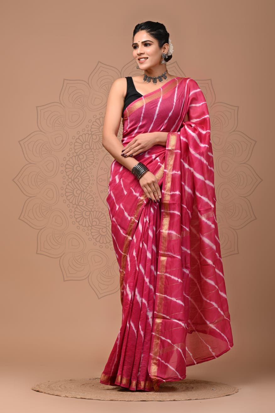 Woman draped in pink Shibori hand block printed Maheshwari silk saree with gold zari border