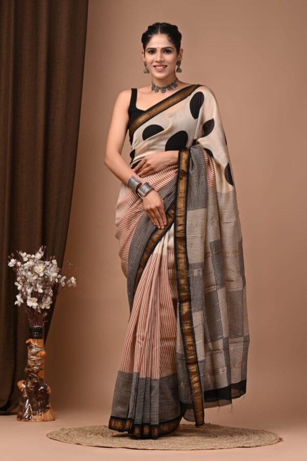Woman wearing peach and beige polka dot hand block printed Maheshwari silk saree with gold zari border