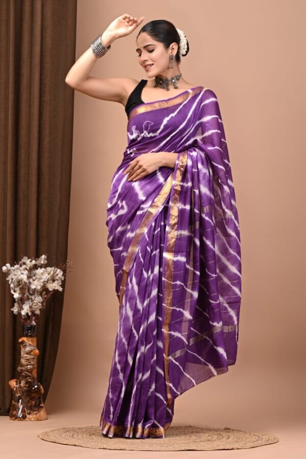 Woman draped in purple Maheshwari silk saree with white shibori stripe pattern and gold zari border