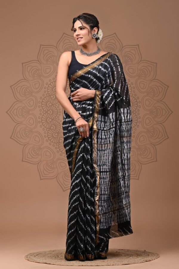 Woman draped in black Maheshwari silk saree with white shibori stripes and gold zari border