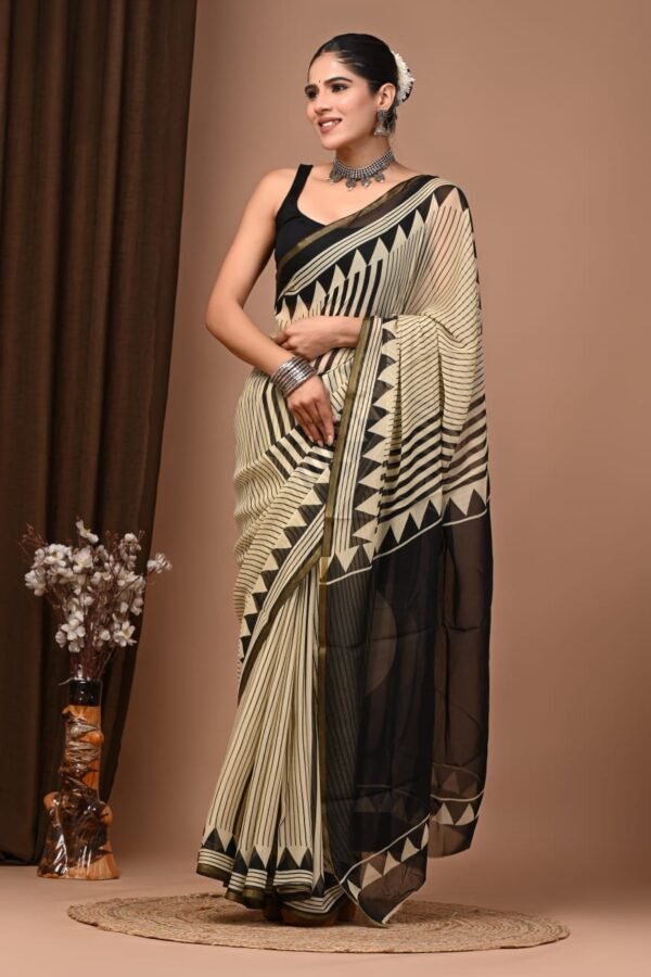 Woman wearing black and cream hand block printed chiffon saree with striped chevron border