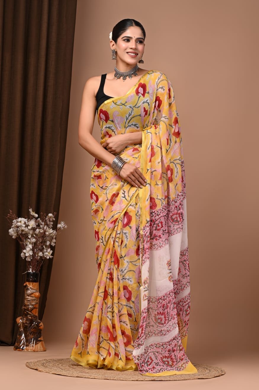 Woman draped in yellow hand block printed chiffon saree with floral motif and pink floral pallu border