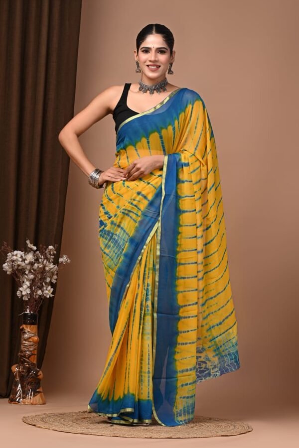 Woman draped in yellow and blue hand block printed chiffon saree with shibori sunburst pattern