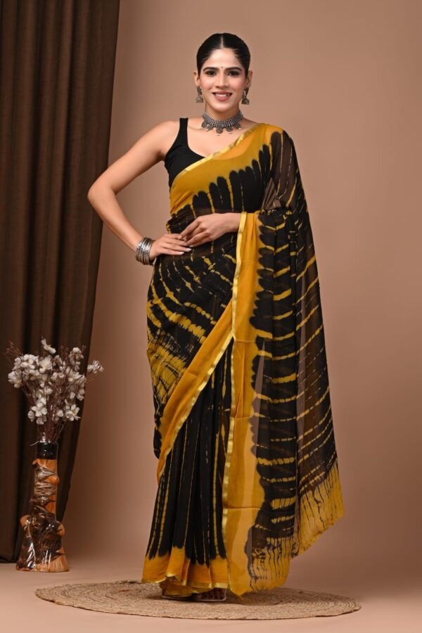 Woman wearing black and mustard hand block printed chiffon saree with shibori burst pattern