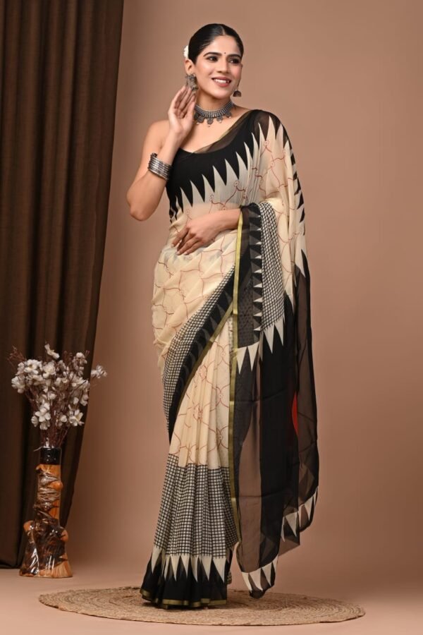 Woman in cream and black hand block printed chiffon saree with zigzag chevron border and floral booti print