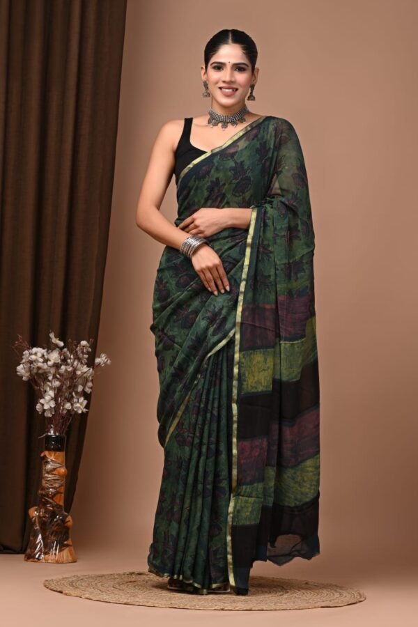 Woman wearing dark green hand block printed floral chiffon saree with gold border and striped pallu