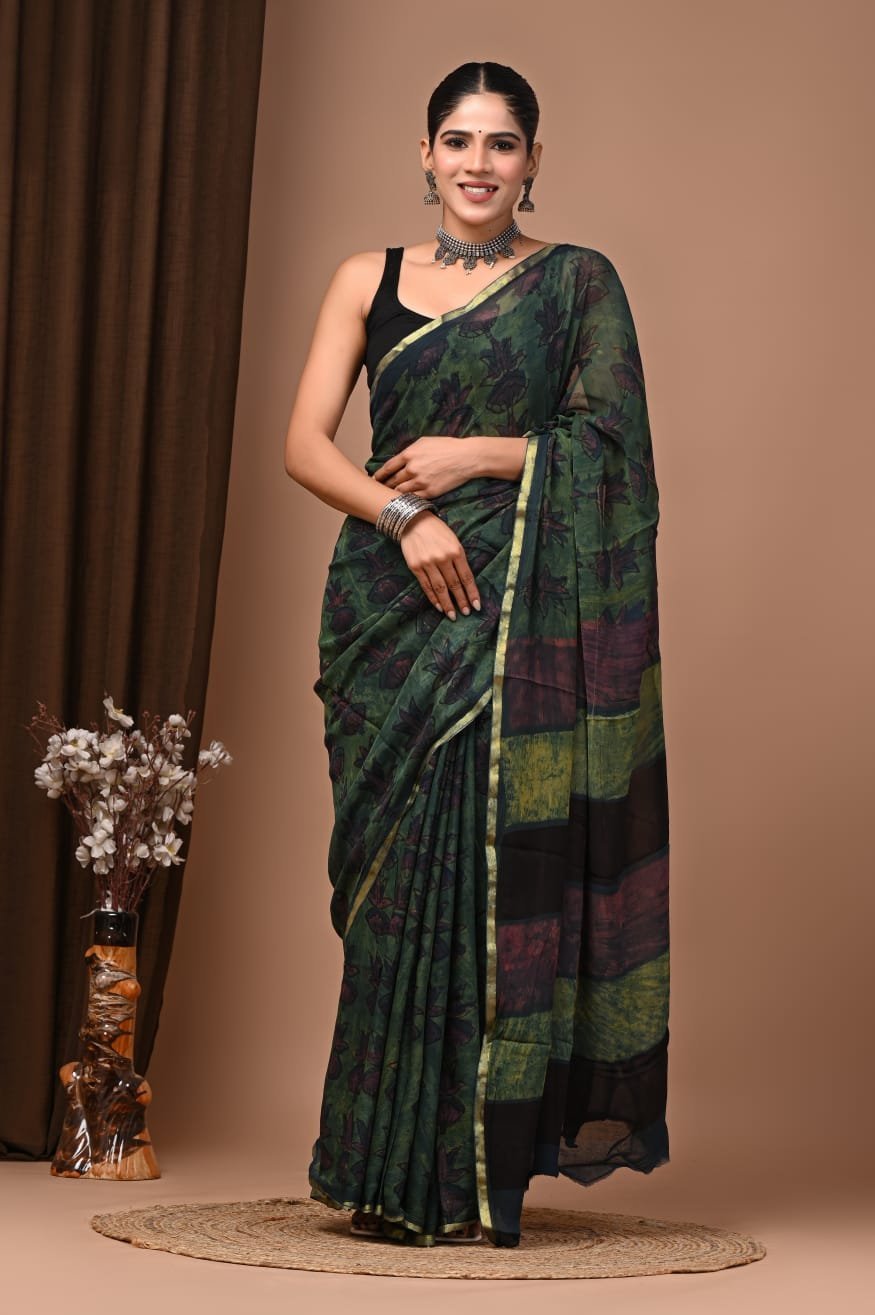 Woman wearing dark green hand block printed floral chiffon saree with gold border and striped pallu
