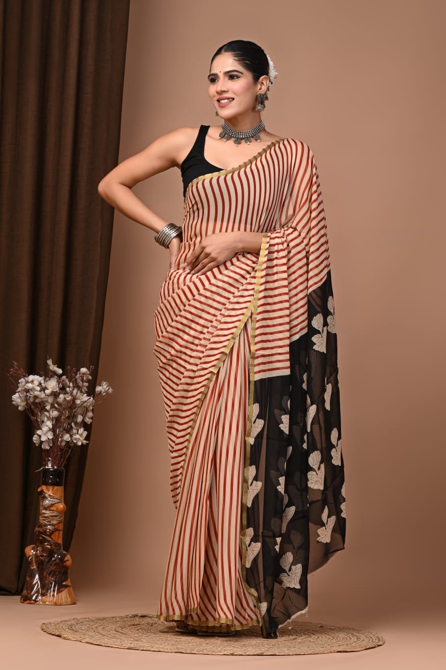 Woman wearing rust-red striped hand block printed chiffon saree with black floral pallu