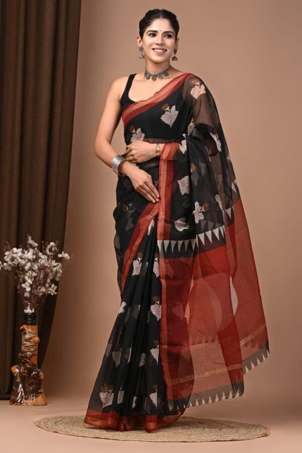 Woman wearing black Kota Doria cotton saree with leaf print and rust red temple border