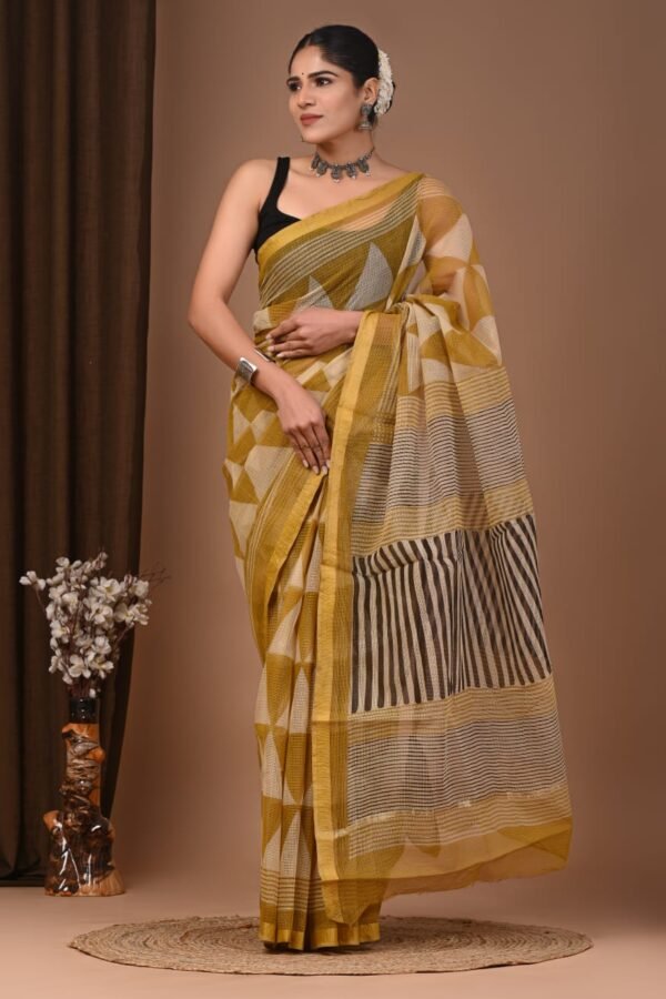 Woman draped in mustard yellow Kota Doria cotton saree with geometric block print and striped pallu