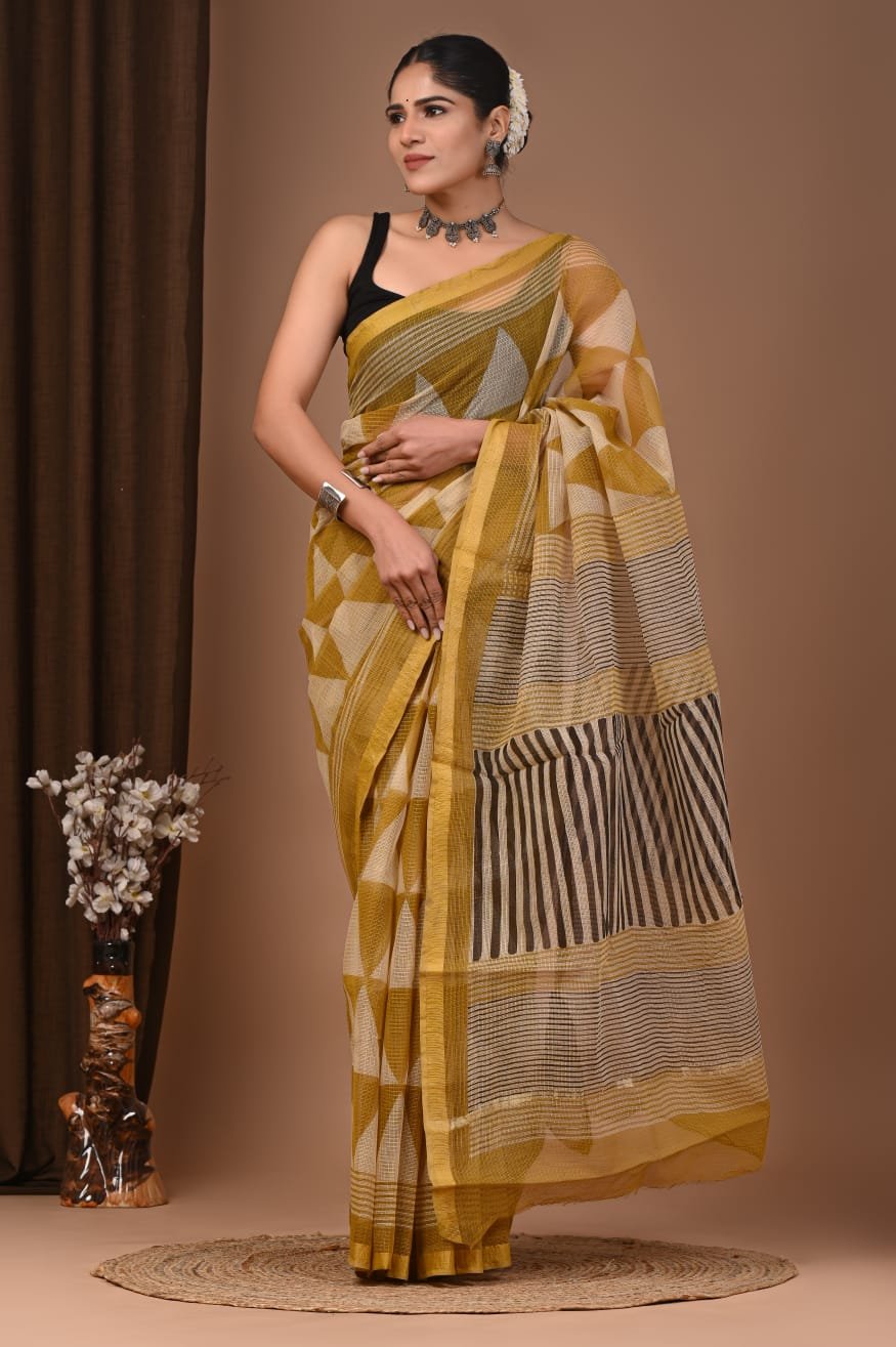 Woman draped in mustard yellow Kota Doria cotton saree with geometric block print and striped pallu