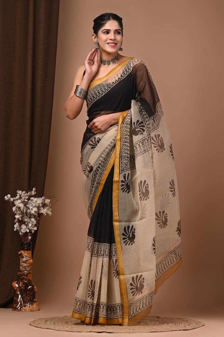 Woman wearing off-white Kota Doria cotton saree with peacock print and gold border