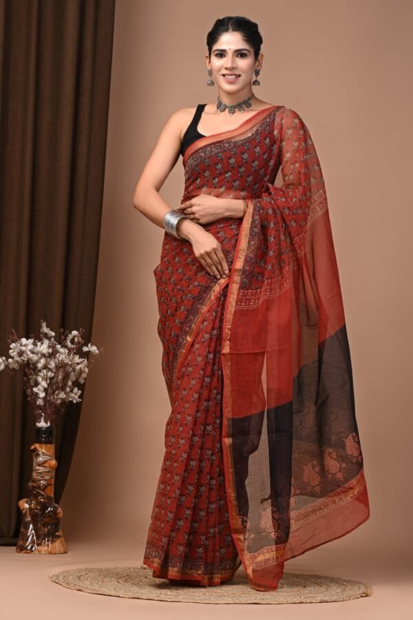 Woman wearing rust red Kota Doria cotton saree with floral booti print and black paisley pallu