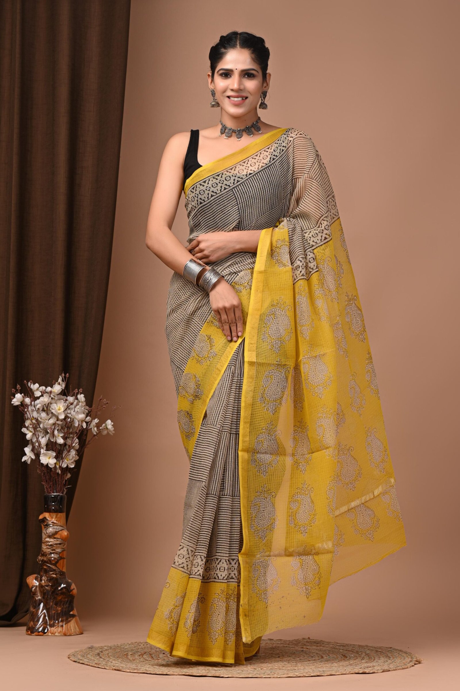 Woman wearing grey striped Kota Doria cotton saree with yellow hand block printed floral border