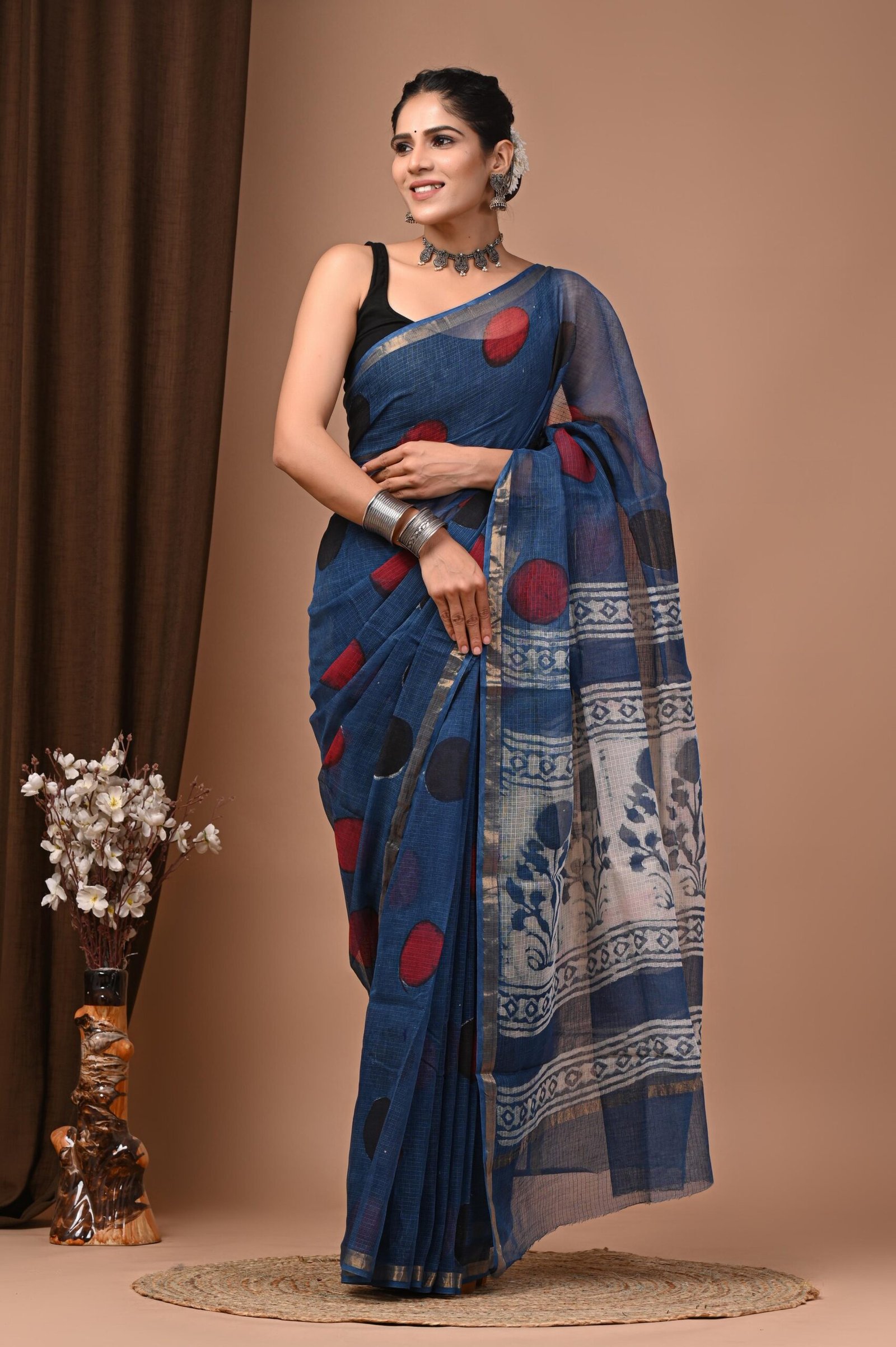 Woman wearing teal blue hand block printed Kota Doria cotton saree with polka dots and floral pallu