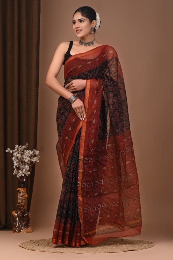 Woman in black and rust paisley hand block printed Kota Doria cotton saree with zari-edged border