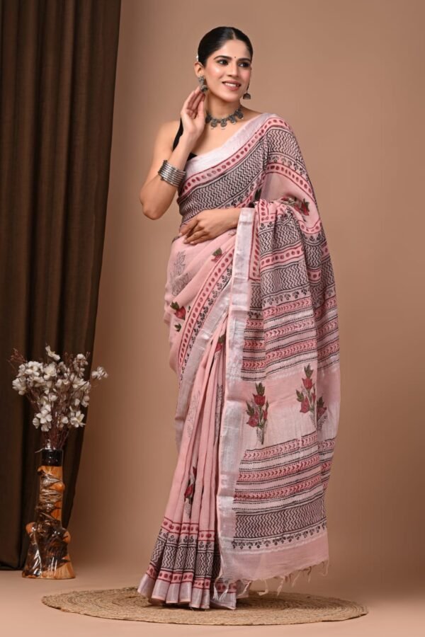 Woman wearing pink hand block printed linen cotton saree with floral motifs and zigzag striped border