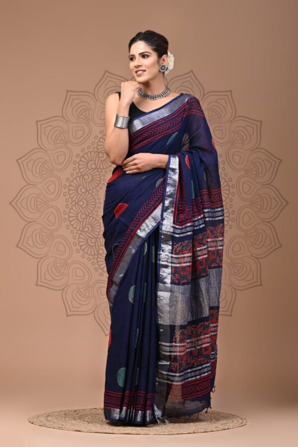 Woman wearing navy blue hand block printed linen cotton saree with silver zari border and red floral pallu