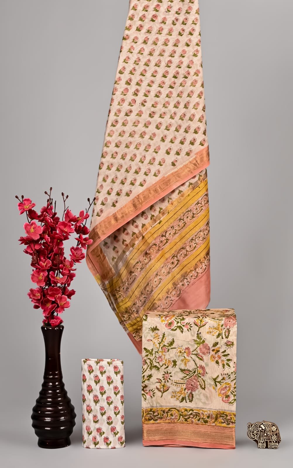 Cream Maheshwari silk suit with pink rosebud booti print and peach scroll-vine border, folded dress material
