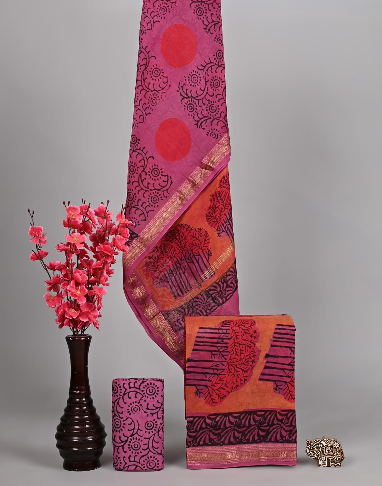 Magenta Maheshwari silk suit with red sunburst print and orange tree branch border with zari trim