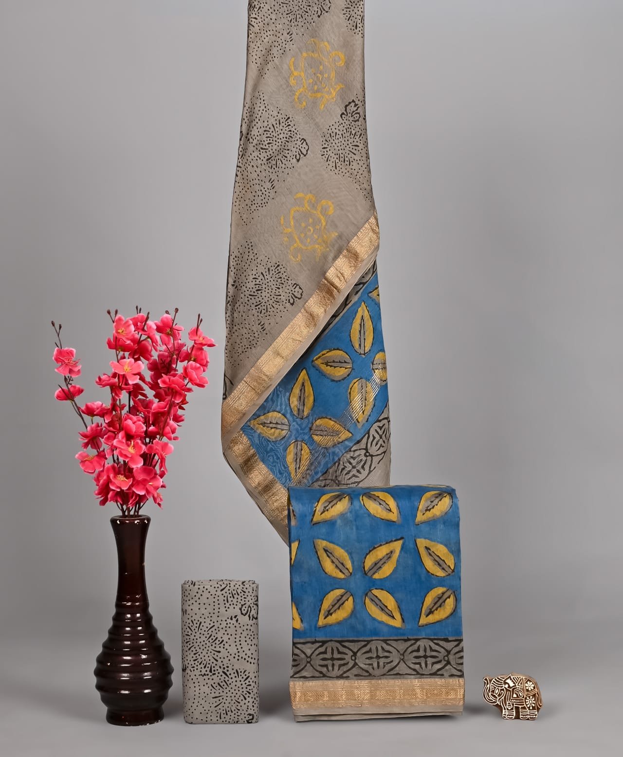 Grey Maheshwari silk suit with medallion print draped beside blue leaf lattice block print dress material