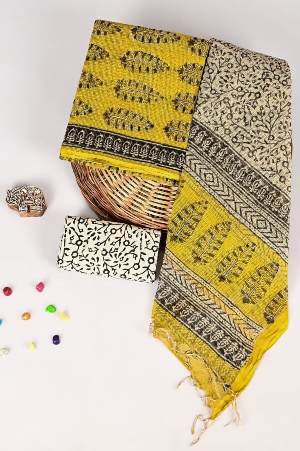 Mustard yellow Kota Doria suit with black feather motif print and zigzag border, folded with cream dupatta piece